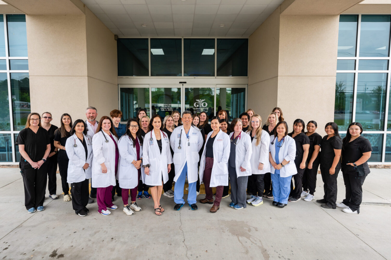 A group of doctors and nurses standing in front of a building.