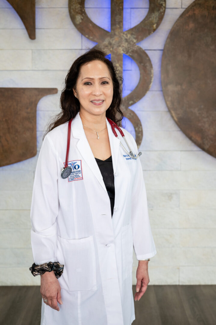 A woman in white lab coat holding a black bag.